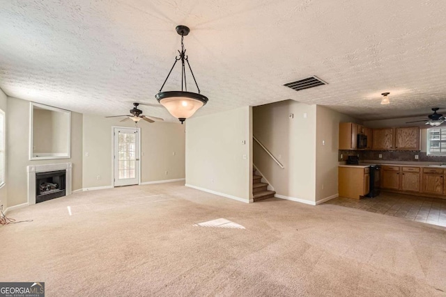 484 Cathedral Dr, Mcdonough, GA 30253 - unfurnished living room featuring a ceiling fan, a textured ceiling, healthy amount of natural light, baseboards, and light colored carpet