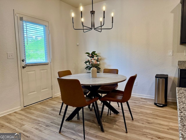3836 Saddle Hill Way, Douglasville, GA 30135 - dining space featuring light wood-style flooring, a chandelier, baseboards, and a textured wall