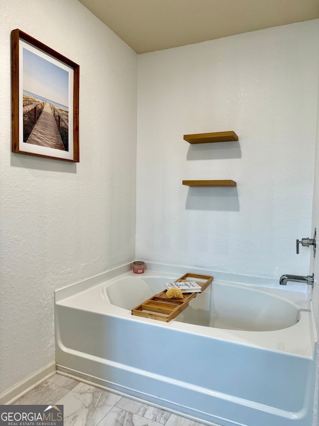 3836 Saddle Hill Way, Douglasville, GA 30135 - bathroom featuring a bath, baseboards, and marble finish floors
