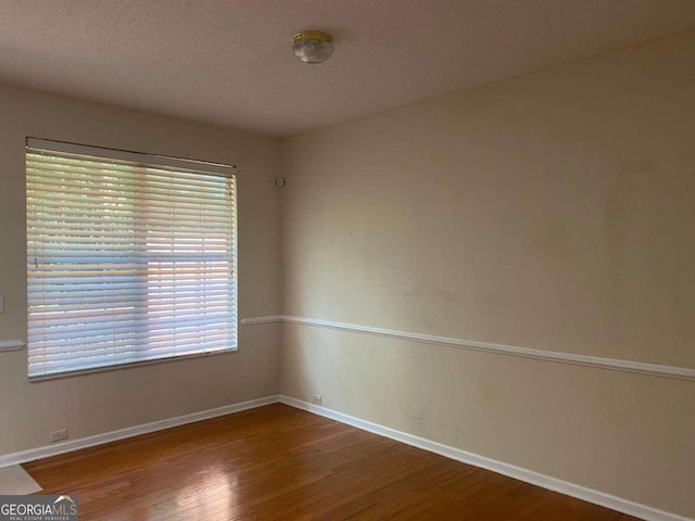 2858 Parkway Close, Lithonia, GA 30058 - spare room featuring wood finished floors, baseboards, and a textured ceiling
