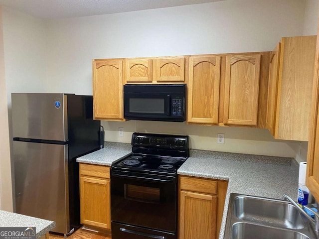 2858 Parkway Close, Lithonia, GA 30058 - kitchen featuring black appliances, a sink, and light countertops