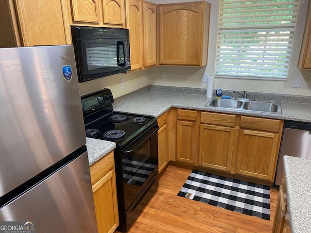 2858 Parkway Close, Lithonia, GA 30058 - kitchen with black appliances, a sink, light countertops, and light wood-style flooring