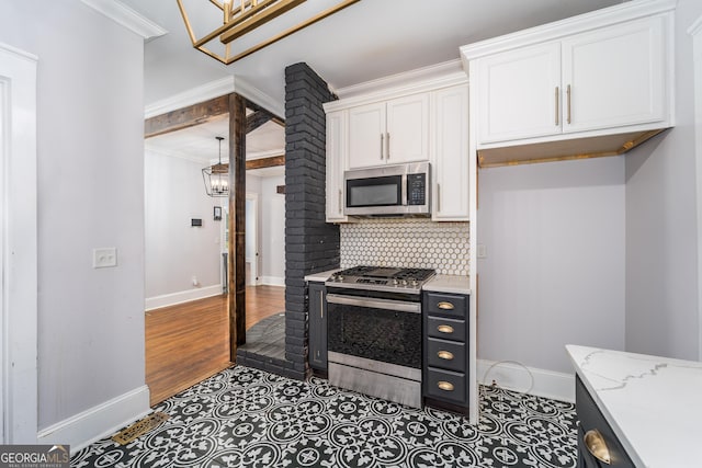 805 S Lee St, Fitzgerald, GA 31750 - kitchen featuring stainless steel appliances, baseboards, white cabinets, tasteful backsplash, and a chandelier