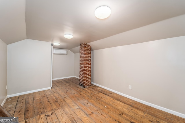 805 S Lee St, Fitzgerald, GA 31750 - additional living space with hardwood / wood-style flooring, a wall mounted AC, baseboards, and vaulted ceiling