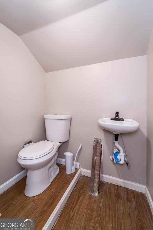 805 S Lee St, Fitzgerald, GA 31750 - bathroom featuring lofted ceiling, toilet, wood finished floors, and baseboards