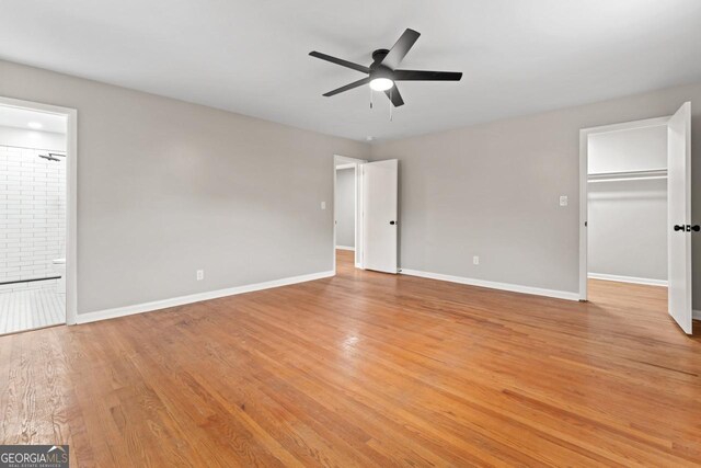 2002 Twin Falls Rd, Decatur, GA 30032 - unfurnished bedroom featuring baseboards, light wood-type flooring, connected bathroom, and a spacious closet