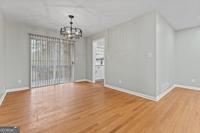 2002 Twin Falls Rd, Decatur, GA 30032 - unfurnished dining area with a chandelier, light wood-style floors, baseboards, and a sink