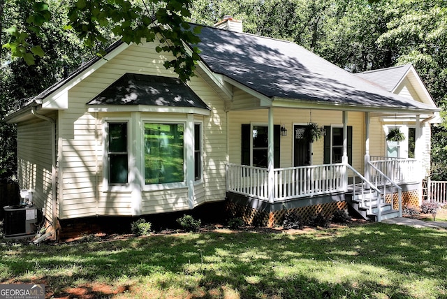 3908 Kilgore Falls Dr, Gainesville, GA 30507 - view of front of house featuring covered porch, a chimney, roof with shingles, a front lawn, and central air condition unit