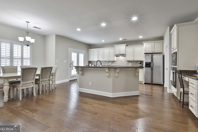 97 Senoya Ln, Senoia, GA 30276 - kitchen featuring stainless steel appliances, a chandelier, a breakfast bar area, tasteful backsplash, and a center island with sink