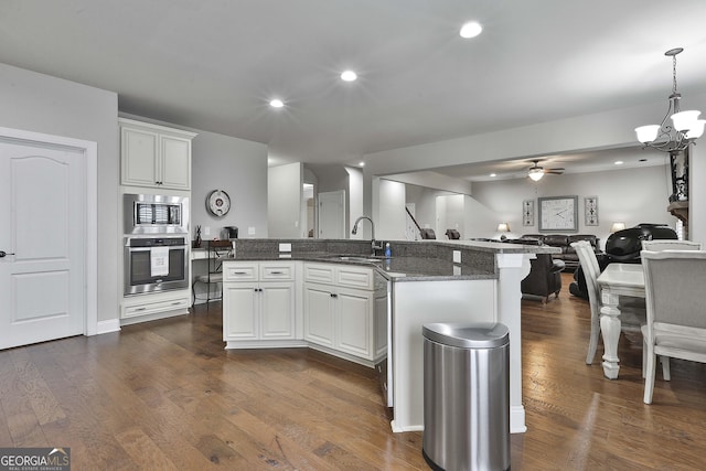 97 Senoya Ln, Senoia, GA 30276 - kitchen featuring stainless steel appliances, a sink, open floor plan, dark wood finished floors, and recessed lighting