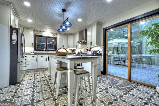 123 Old Fjord Rd, Blue Ridge, GA 30513 - kitchen with wall chimney range hood, dark countertops, freestanding refrigerator, decorative backsplash, and recessed lighting