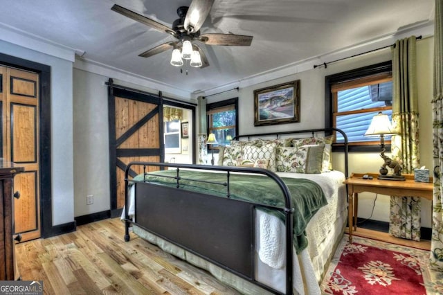 123 Old Fjord Rd, Blue Ridge, GA 30513 - bedroom featuring wood finished floors, crown molding, a barn door, multiple windows, and baseboards