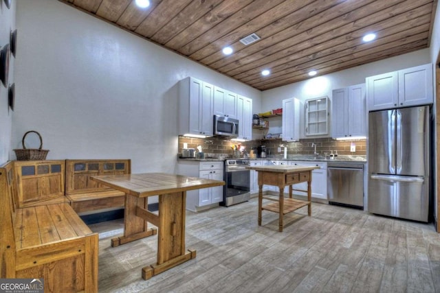 123 Old Fjord Rd, Blue Ridge, GA 30513 - kitchen with appliances with stainless steel finishes, wooden ceiling, light wood-style flooring, decorative backsplash, and white cabinets
