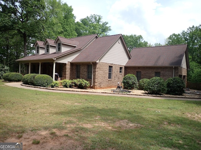 185 Kinards Mill Rd, Jackson, GA 30233 - new england style home with brick siding, a front yard, and roof with shingles