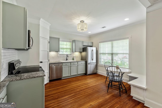 148 Jackson St, Newnan, GA 30263 - kitchen featuring stainless steel appliances, a sink, dark wood finished floors, backsplash, and crown molding