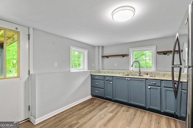 148 Jackson St, Newnan, GA 30263 - kitchen featuring a sink, open shelves, freestanding refrigerator, light wood-type flooring, and baseboards