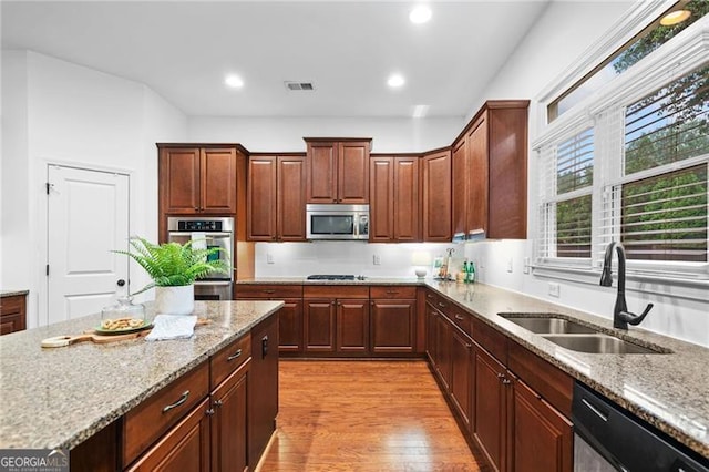 910 Ovalene Ln SW, Marietta, GA 30064 - kitchen with stainless steel appliances, a sink, light wood-style flooring, light stone countertops, and recessed lighting