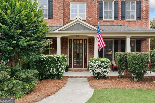 910 Ovalene Ln SW, Marietta, GA 30064 - doorway to property with brick siding, covered porch, and a shingled roof