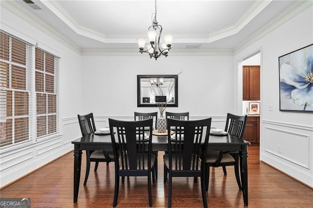 910 Ovalene Ln SW, Marietta, GA 30064 - dining room featuring a chandelier, dark wood-type flooring, crown molding, a tray ceiling, and wainscoting