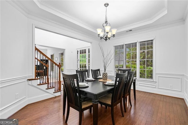 910 Ovalene Ln SW, Marietta, GA 30064 - dining space featuring a chandelier, stairway, ornamental molding, wood-type flooring, and a decorative wall