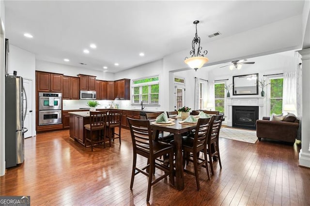 910 Ovalene Ln SW, Marietta, GA 30064 - dining area featuring healthy amount of natural light, dark wood finished floors, a glass covered fireplace, a ceiling fan, and recessed lighting