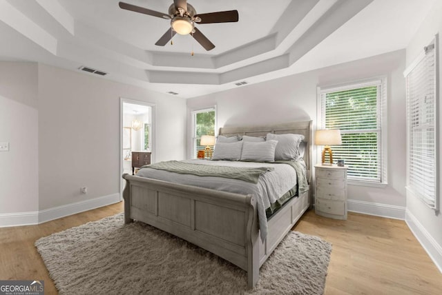 3652 Shady Oak Trl, Gainesville, GA 30506 - bedroom featuring a raised ceiling, light wood-style flooring, a ceiling fan, and connected bathroom