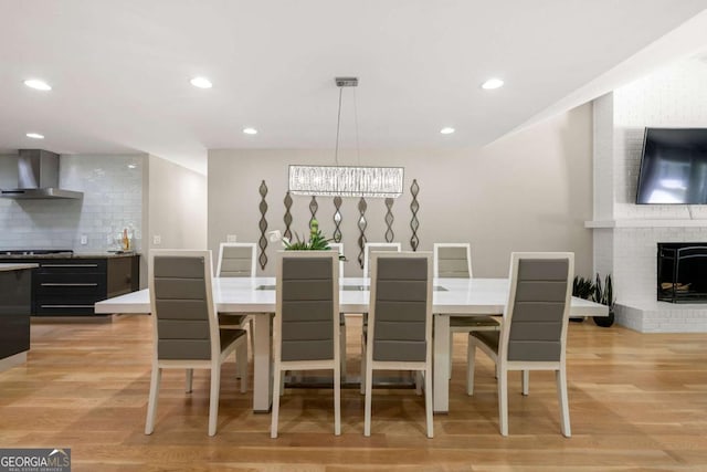 9701 Buice Rd, Alpharetta, GA 30022 - dining room featuring light wood-type flooring, a brick fireplace, and recessed lighting