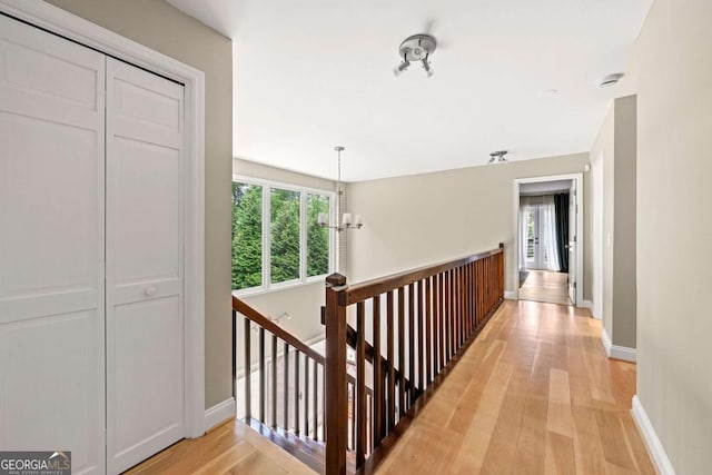 9701 Buice Rd, Alpharetta, GA 30022 - hallway with an upstairs landing, plenty of natural light, light wood-style flooring, and baseboards