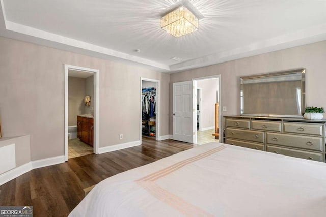 9701 Buice Rd, Alpharetta, GA 30022 - bedroom featuring baseboards, wood finished floors, a spacious closet, a closet, and ensuite bathroom