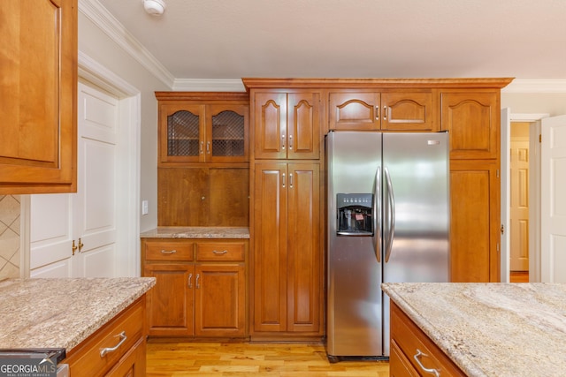 302 Brookwood Ln, Lafayette, GA 30728 - kitchen with stainless steel fridge, brown cabinets, light stone countertops, crown molding, and light wood-style floors