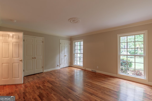 302 Brookwood Ln, Lafayette, GA 30728 - unfurnished bedroom with wood finished floors, crown molding, baseboards, and multiple closets