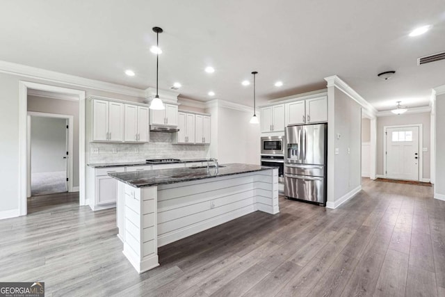 1824 Alberta Ln, Winder, GA 30680 - kitchen featuring appliances with stainless steel finishes, tasteful backsplash, light wood-style flooring, an island with sink, and ornamental molding