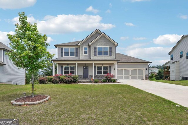 1824 Alberta Ln, Winder, GA 30680 - craftsman house with a garage, driveway, stone siding, covered porch, and a front yard