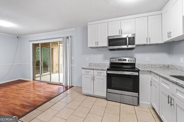 3626 Buford Hwy Unit C1, Brookhaven, GA 30329 - kitchen with appliances with stainless steel finishes, white cabinets, light tile patterned floors, a textured ceiling, and light stone counters