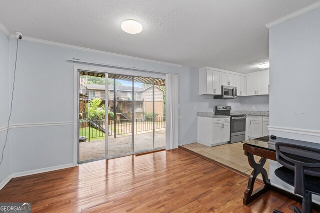 3626 Buford Hwy Unit C1, Brookhaven, GA 30329 - kitchen with stainless steel appliances, light wood-type flooring, white cabinets, crown molding, and light stone countertops