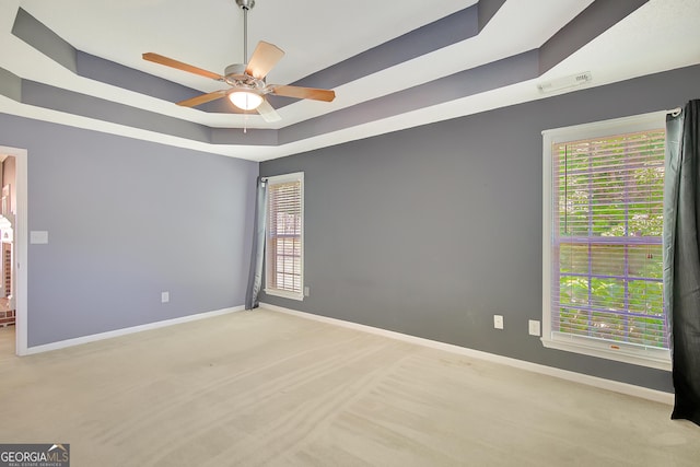 85 Parks Pl, Sharpsburg, GA 30277 - spare room featuring a raised ceiling, baseboards, ceiling fan, and healthy amount of natural light
