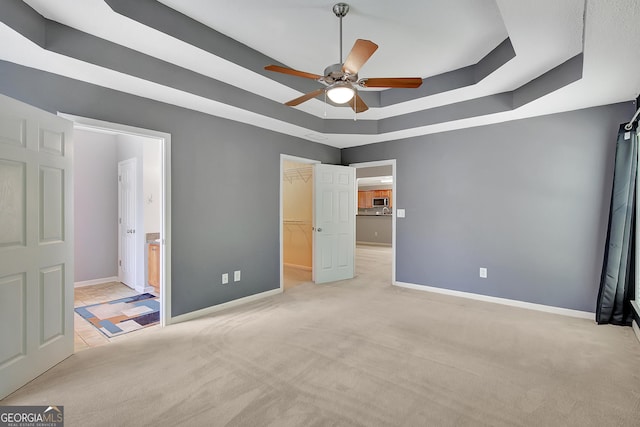 85 Parks Pl, Sharpsburg, GA 30277 - unfurnished bedroom with a raised ceiling, baseboards, light colored carpet, a spacious closet, and ensuite bath
