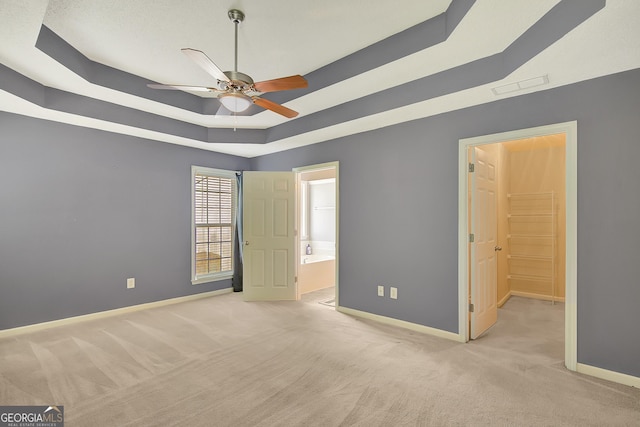 85 Parks Pl, Sharpsburg, GA 30277 - unfurnished bedroom with a raised ceiling, light colored carpet, baseboards, and connected bathroom