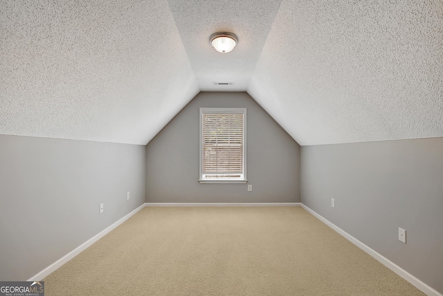 85 Parks Pl, Sharpsburg, GA 30277 - additional living space with a textured ceiling, baseboards, vaulted ceiling, and carpet flooring