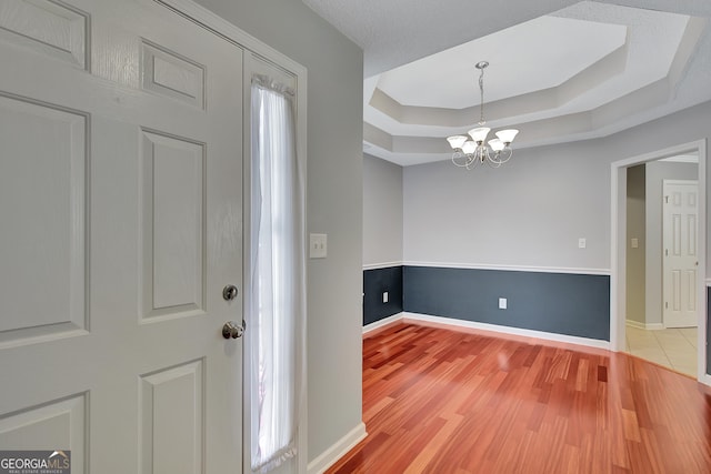 85 Parks Pl, Sharpsburg, GA 30277 - foyer entrance featuring a raised ceiling, a chandelier, light wood-style floors, and baseboards