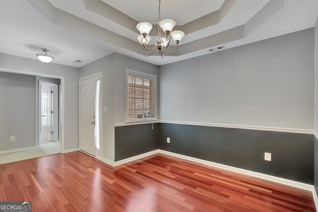 85 Parks Pl, Sharpsburg, GA 30277 - entryway with wood finished floors, a chandelier, baseboards, and a tray ceiling