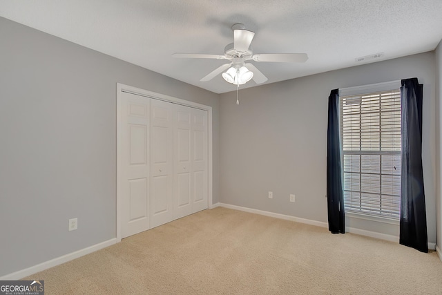 85 Parks Pl, Sharpsburg, GA 30277 - unfurnished bedroom featuring light carpet, multiple windows, baseboards, and a textured ceiling