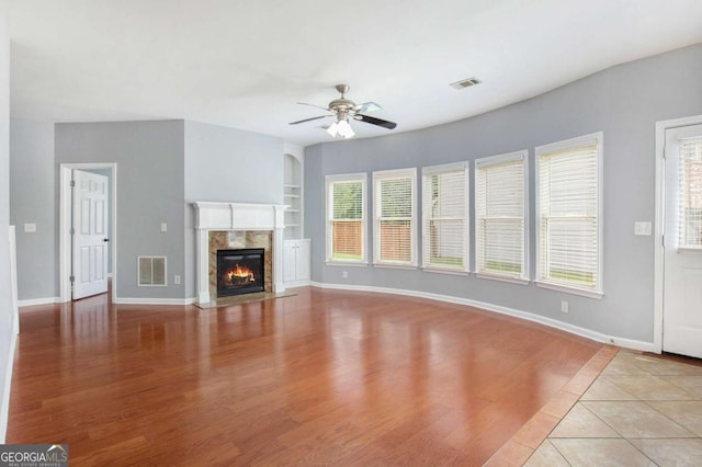 2023 Arbor Springs Way, Buford, GA 30519 - unfurnished living room with a ceiling fan, light wood-style floors, a fireplace, and built in features