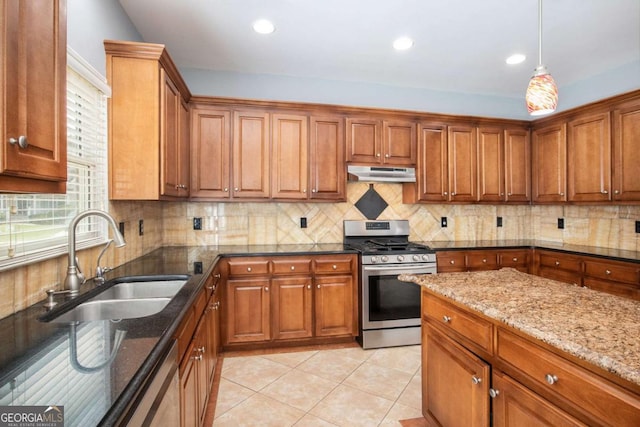 2023 Arbor Springs Way, Buford, GA 30519 - kitchen with appliances with stainless steel finishes, under cabinet range hood, dark stone counters, brown cabinets, and decorative light fixtures