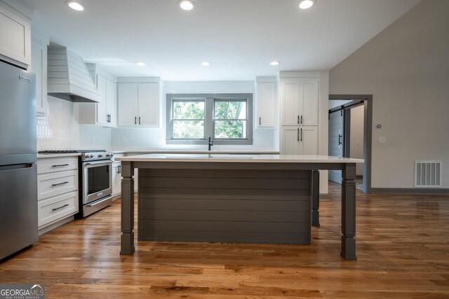 215 Holman Ave, Athens, GA 30606 - kitchen featuring appliances with stainless steel finishes, custom exhaust hood, white cabinets, light countertops, and recessed lighting