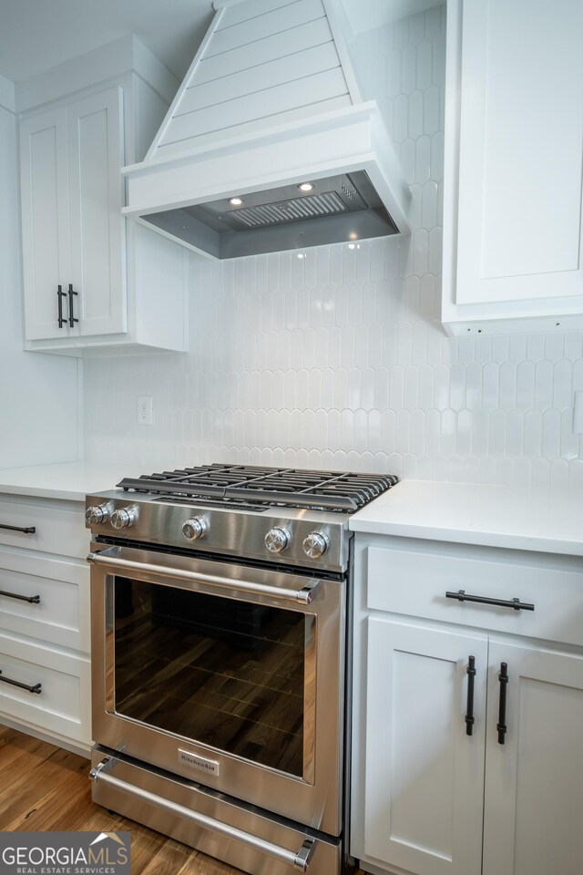 215 Holman Ave, Athens, GA 30606 - kitchen with high end stove, premium range hood, white cabinetry, and light countertops