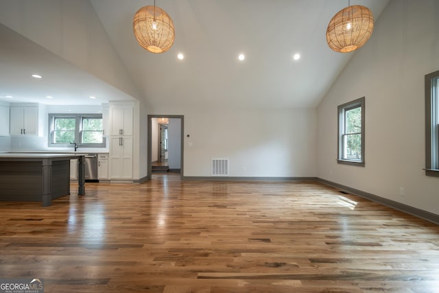 215 Holman Ave, Athens, GA 30606 - unfurnished living room with high vaulted ceiling, wood finished floors, recessed lighting, and baseboards