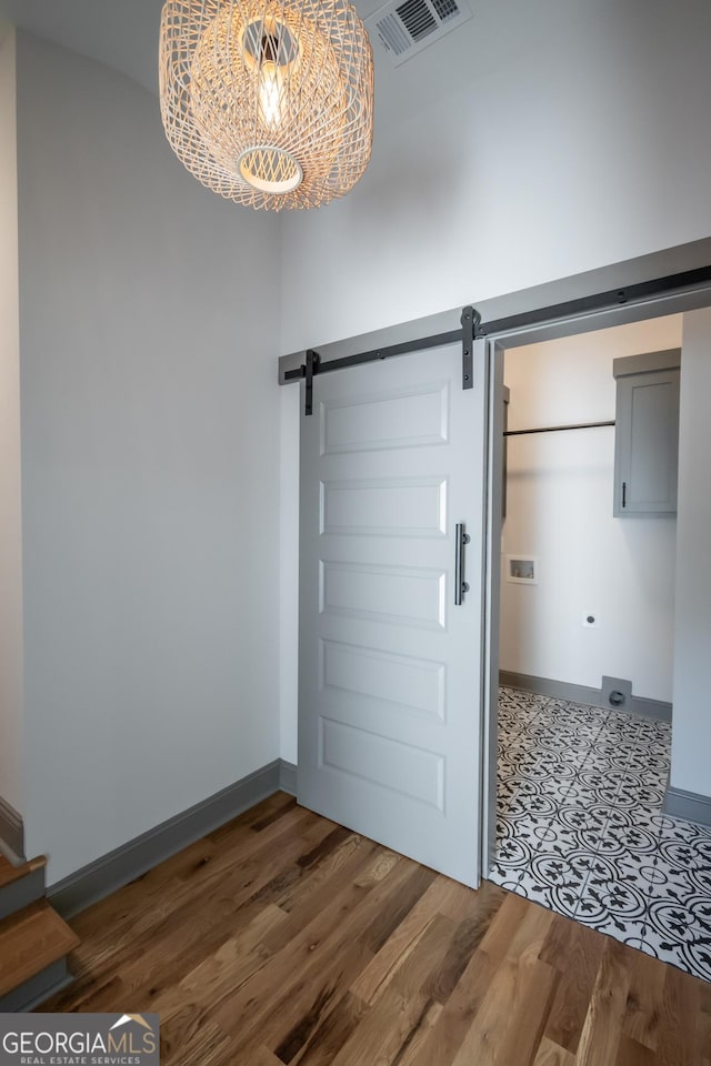 215 Holman Ave, Athens, GA 30606 - entrance foyer with a barn door, baseboards, wood finished floors, and a chandelier