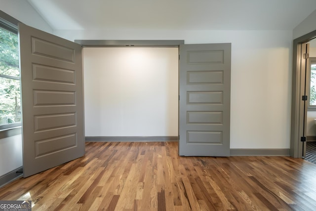 215 Holman Ave, Athens, GA 30606 - empty room featuring wood finished floors, healthy amount of natural light, lofted ceiling, and baseboards