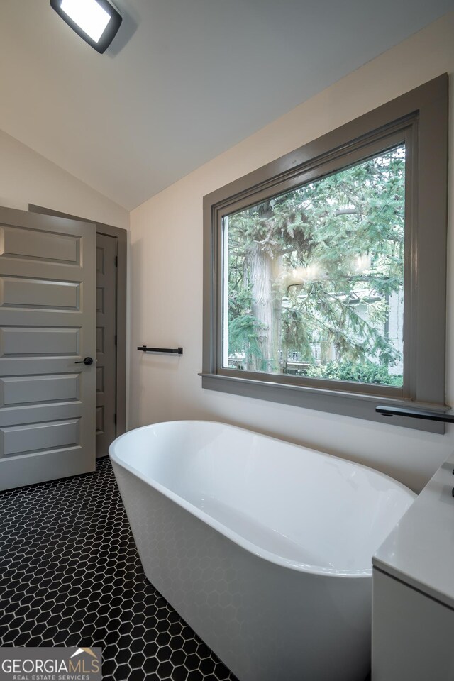 215 Holman Ave, Athens, GA 30606 - full bath featuring a freestanding tub, vaulted ceiling, and vanity